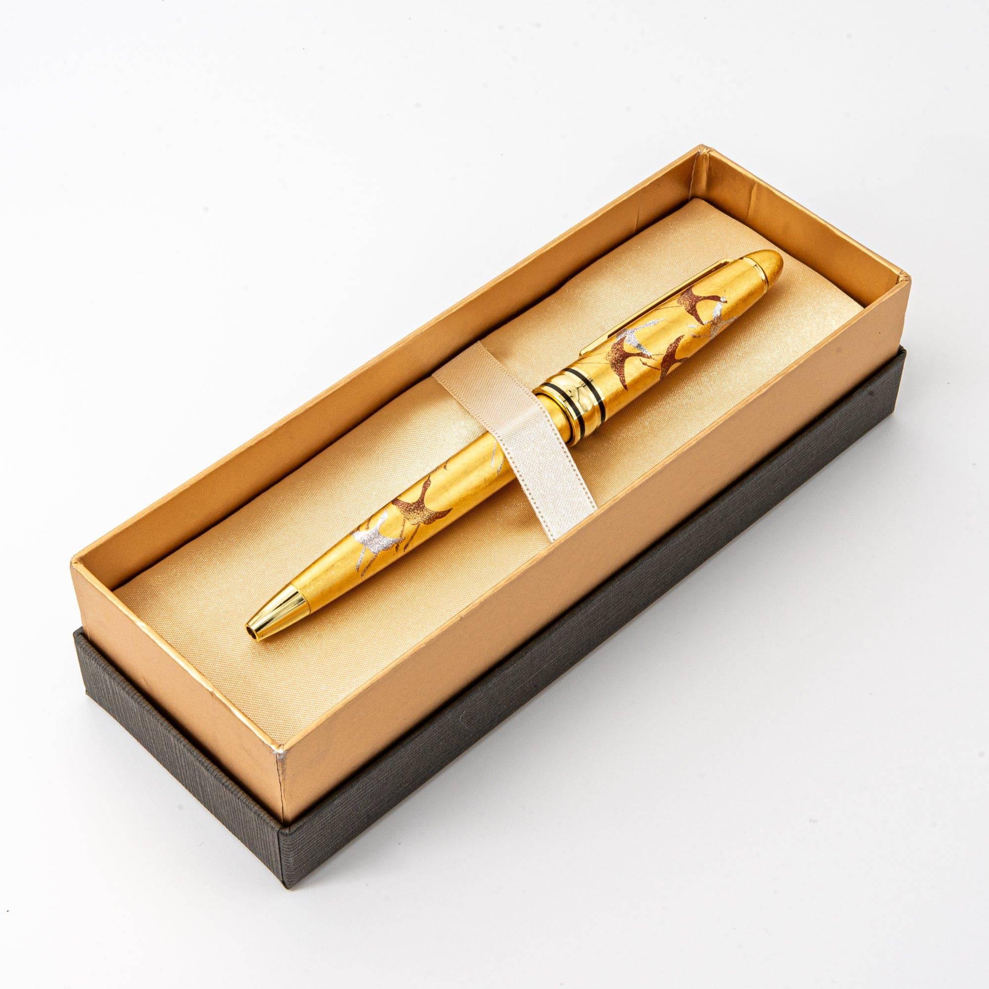 The gold maki-e ballpoint pen displayed in a luxurious golden box, secured with a satin strap, emphasizing its premium craftsmanship.