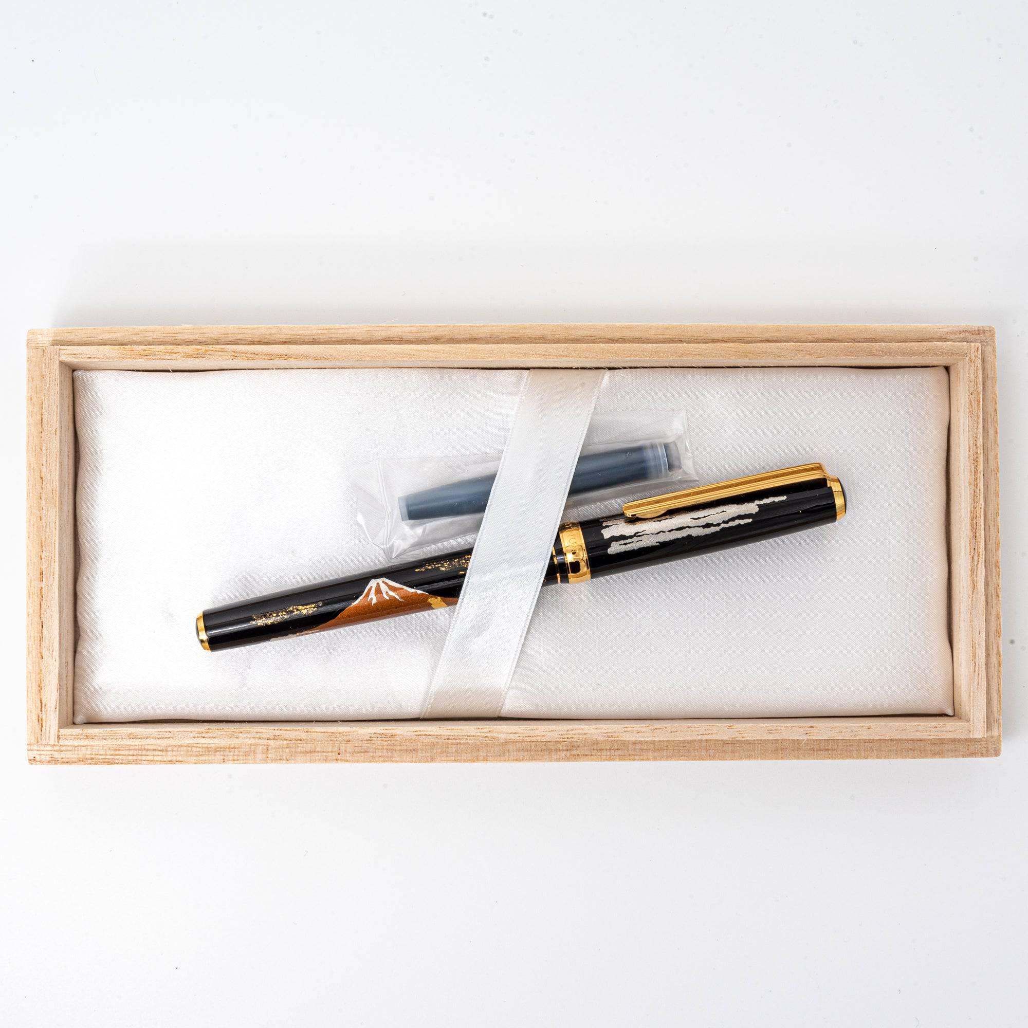 Elegant wooden box labeled "KANAZAWA-HAKU FOUNTAIN PEN," housing a luxury Japanese fountain pen with Mt. Fuji maki-e design and ink cartridges.