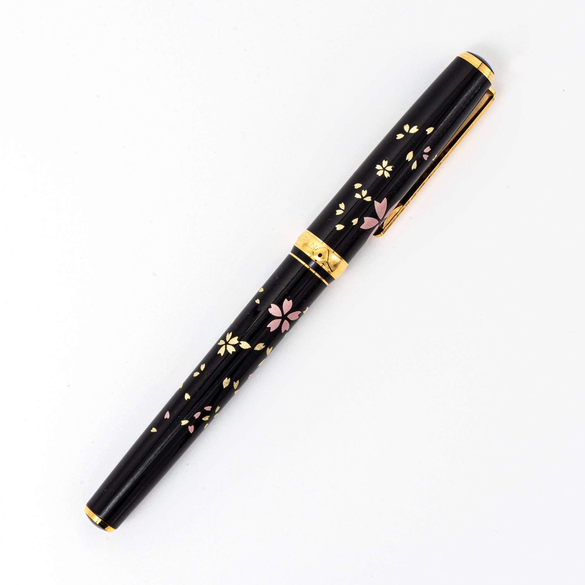 Black Japanese fountain pen featuring gold and pink sakura petals, gold accents, and a glossy finish, symbolizing timeless elegance and tradition.