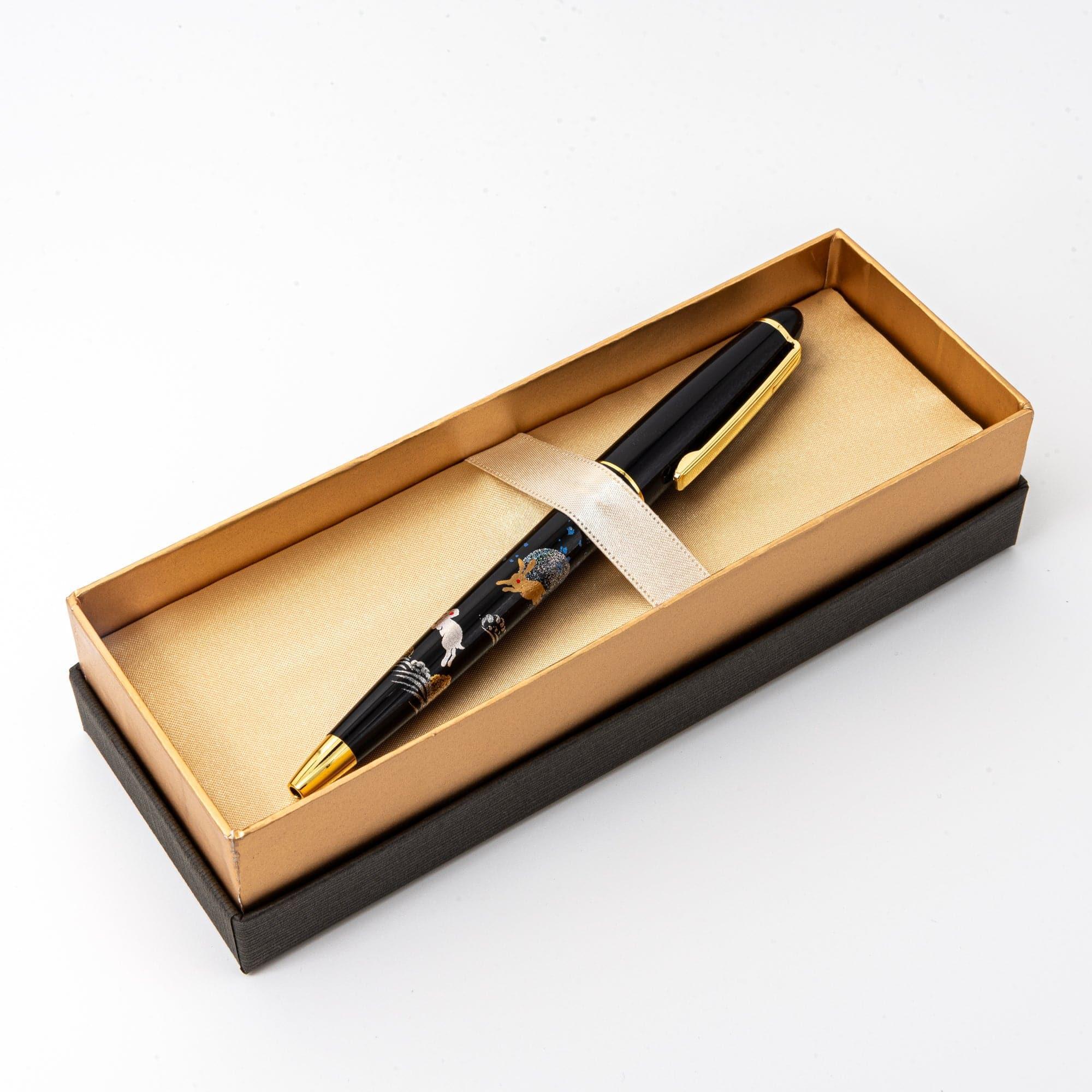 A black ballpoint pen with rabbit and moon motifs displayed in a satin-lined box, exuding sophistication and traditional artistry.