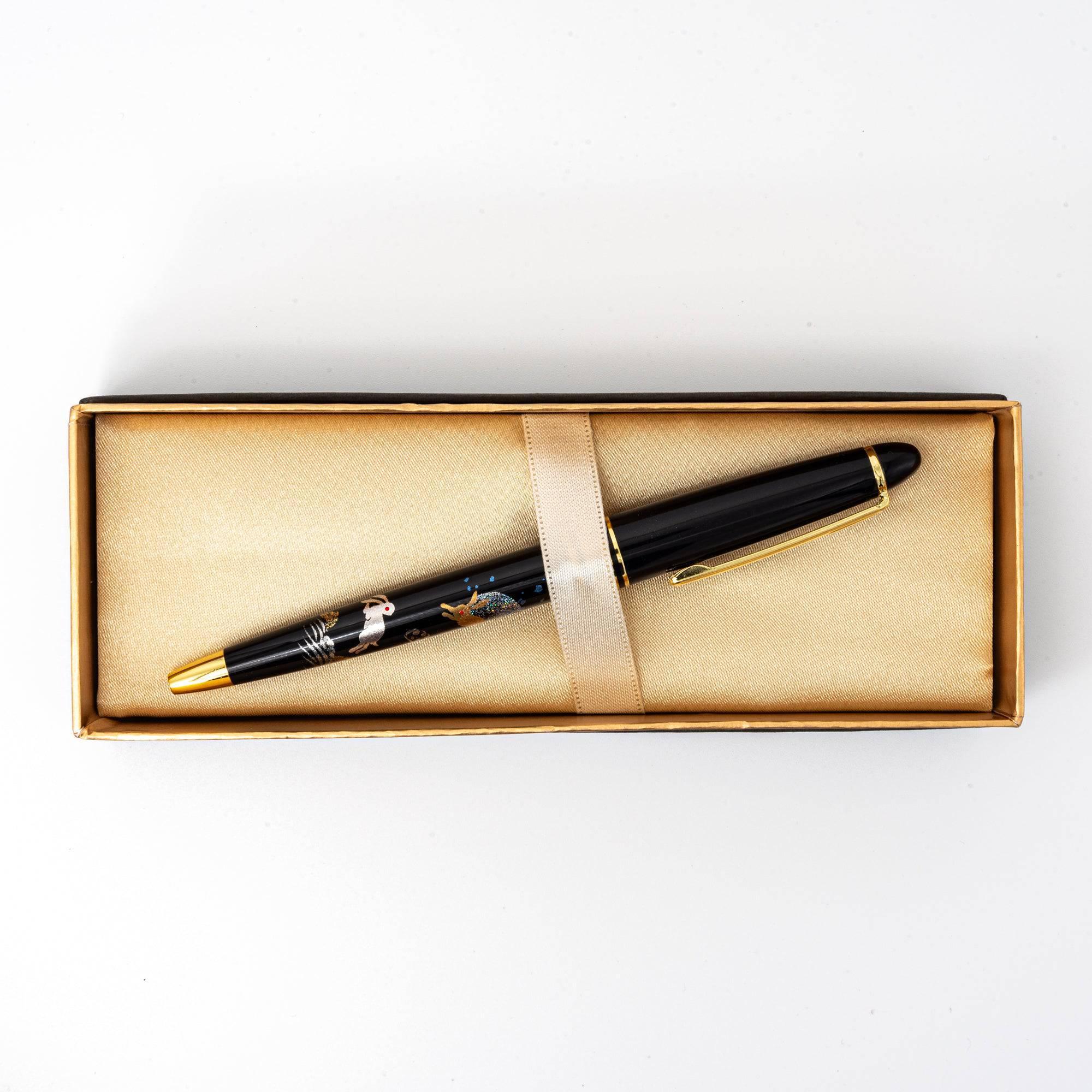 A top view of the black pen in a golden satin-lined box, featuring intricate maki-e rabbit and moon designs, ideal for gifting.