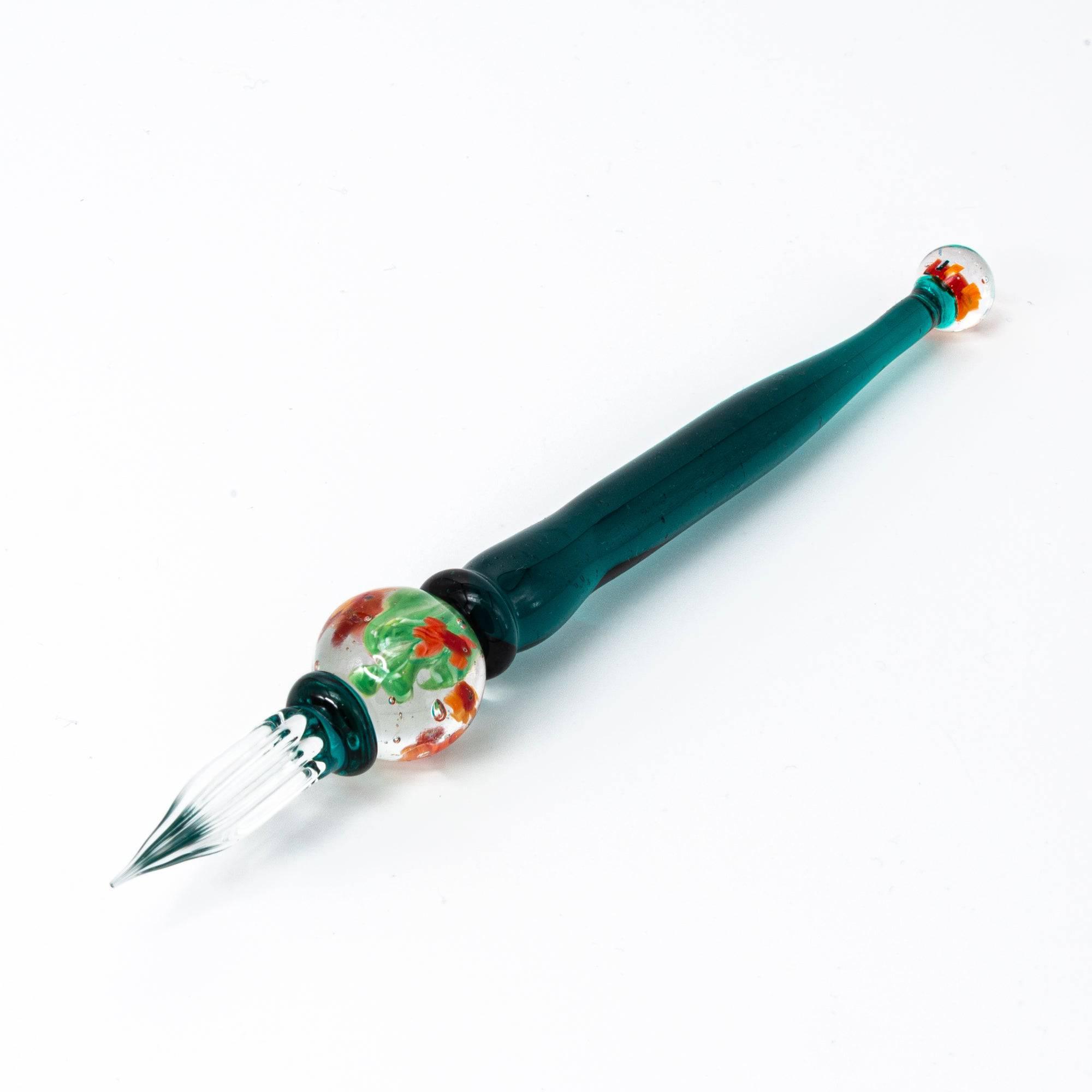 Side view of glass pen with goldfish motif encased like a fishbowl, featuring dark green handle.