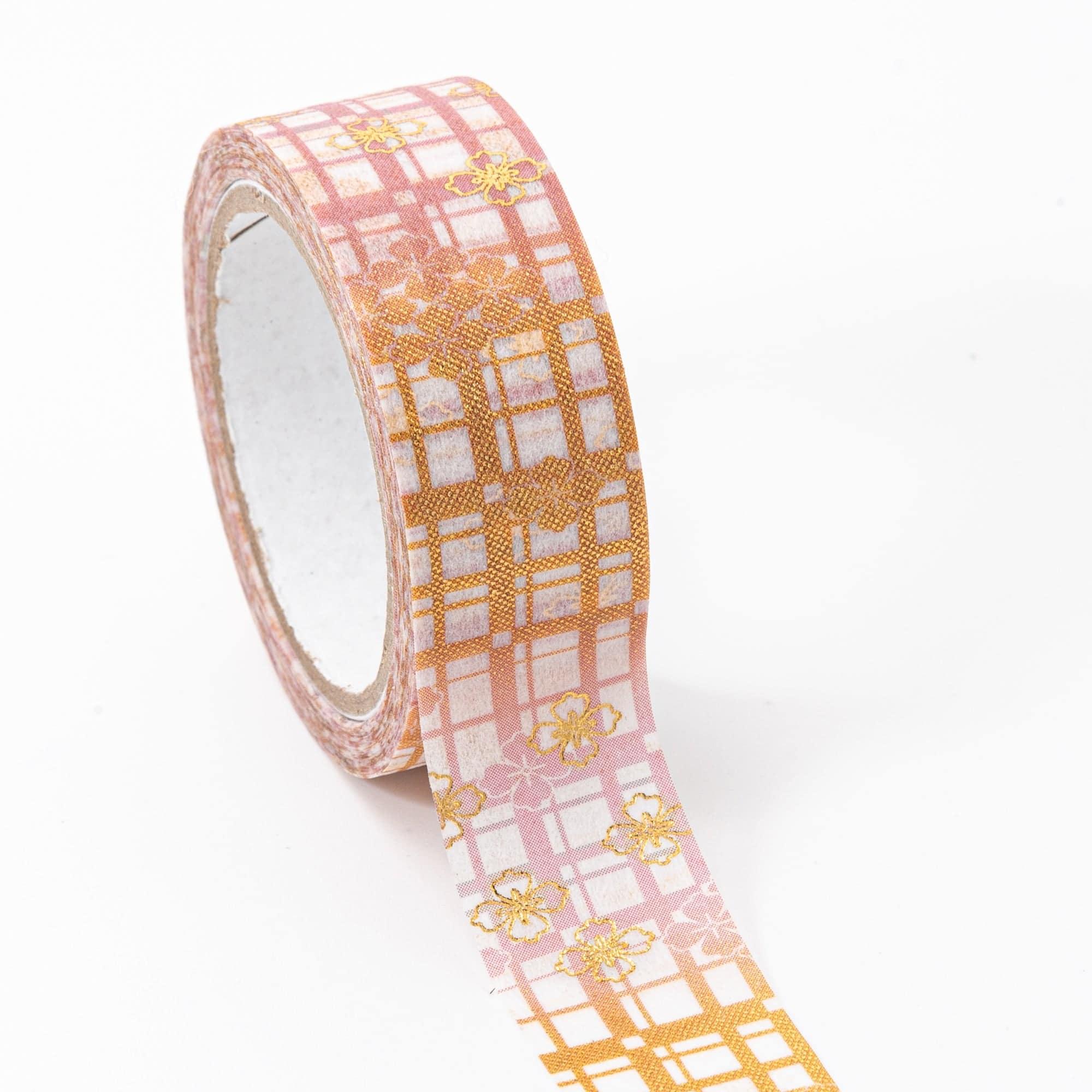 Roll of Iyo Washi Tape with floral lattice designs, unraveling to reveal its artistic motifs, placed on a wooden surface under soft lighting.  