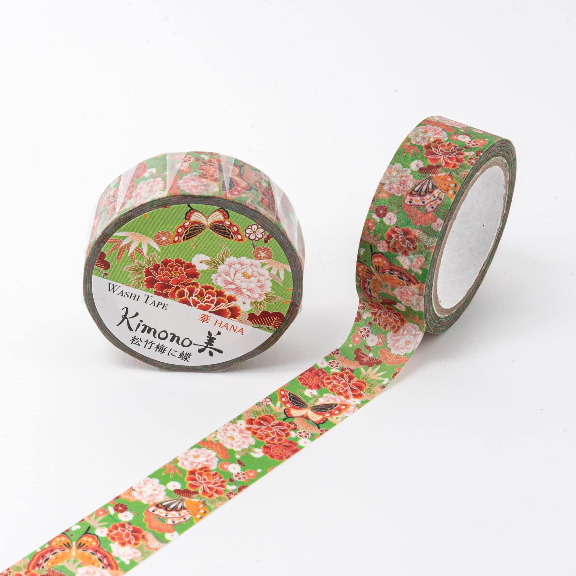 Roll of Iyo Washi Tape with traditional motifs, highlighting its blend of pine, bamboo, plum, and butterfly designs on a desk.  