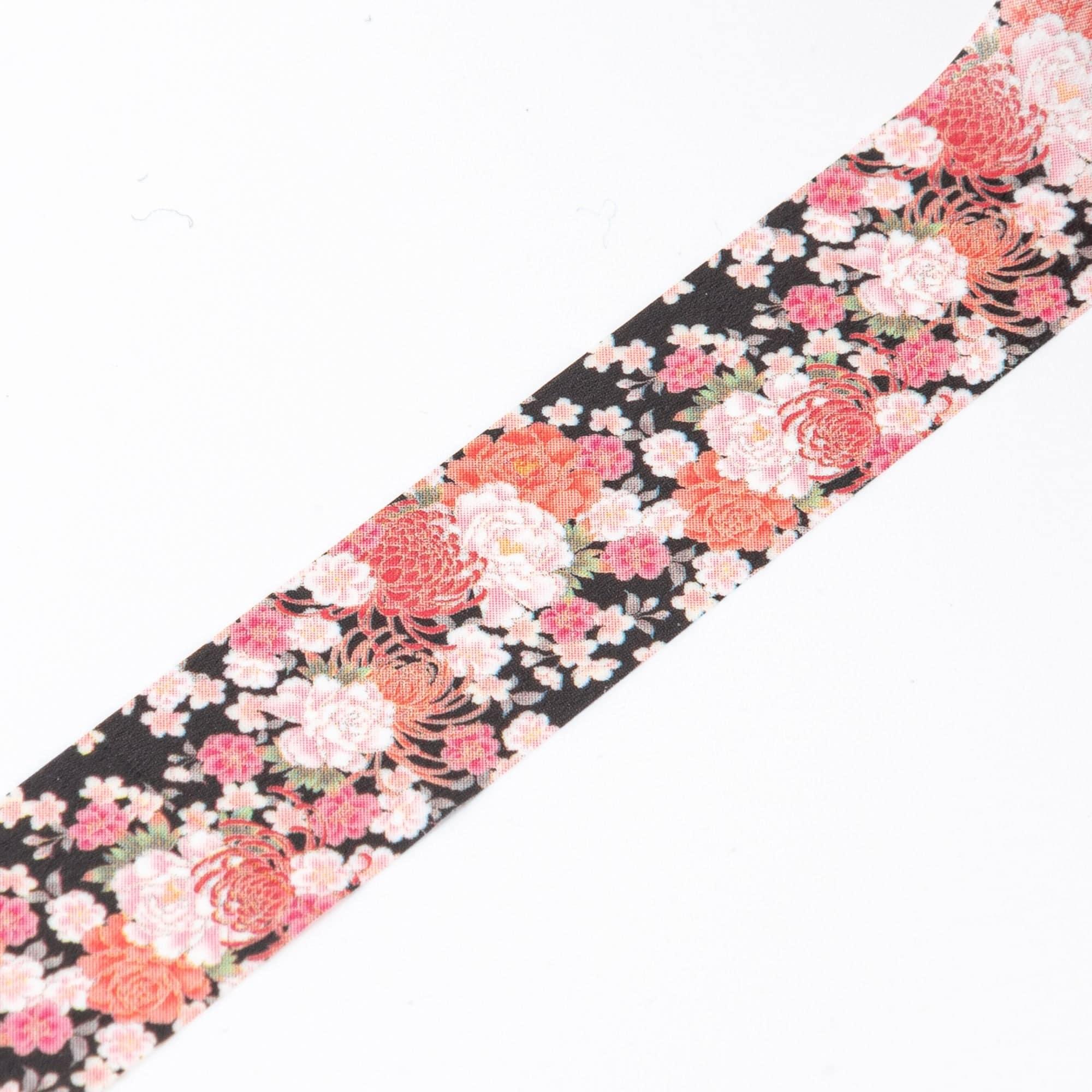 Close-up of Iyo Washi Tape showcasing intricate blossom patterns, emphasizing colorful floral motifs on a natural wooden desk.  