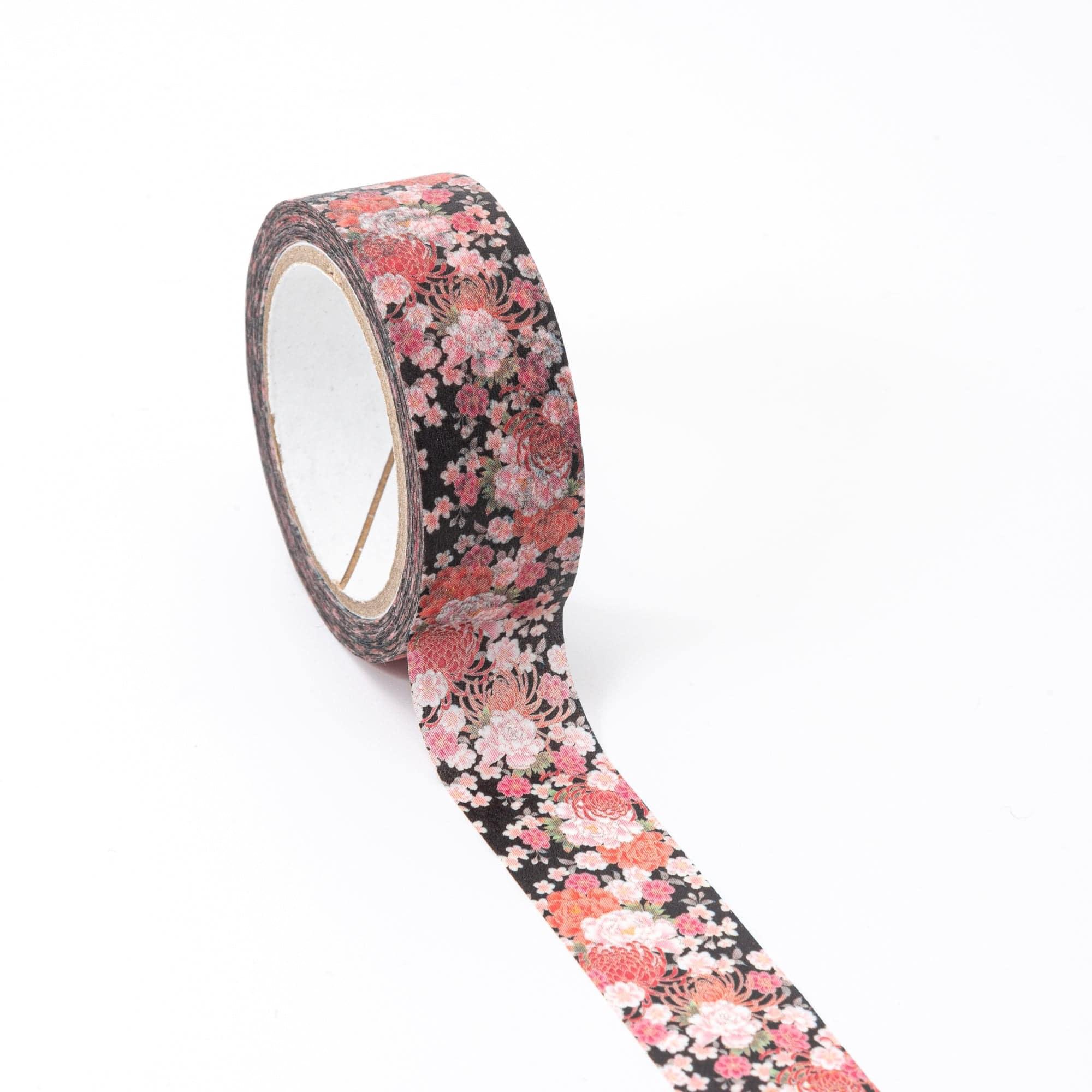 Roll of Iyo Washi Tape with splendid blossoms, unraveling to reveal its detailed floral motifs, placed on a wooden surface under soft light.  