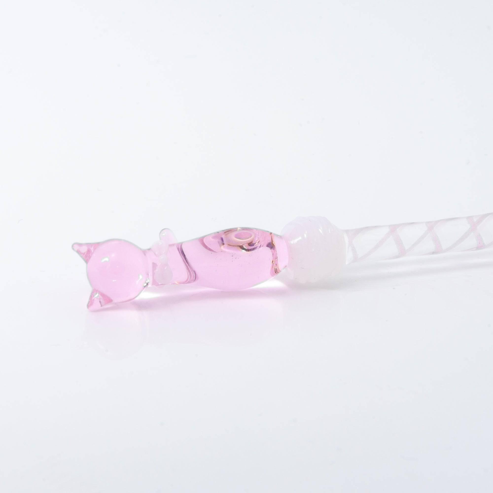 A delicate pink glass dip pen featuring a cat design at the top and a twisted, clear handle, creating a whimsical and elegant look.