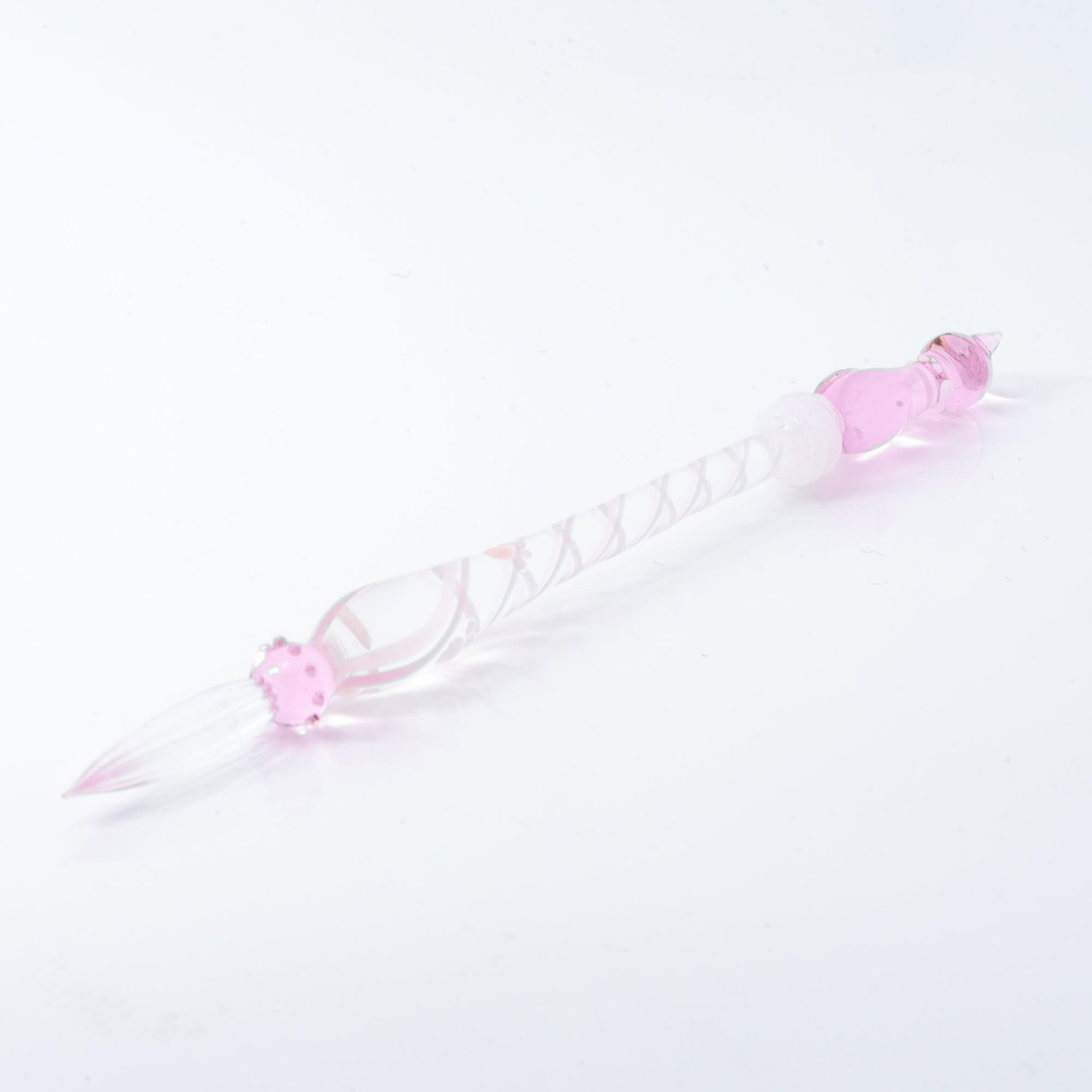 A delicate pink glass dip pen featuring a cat design at the top and a twisted, clear handle, creating a whimsical and elegant look.