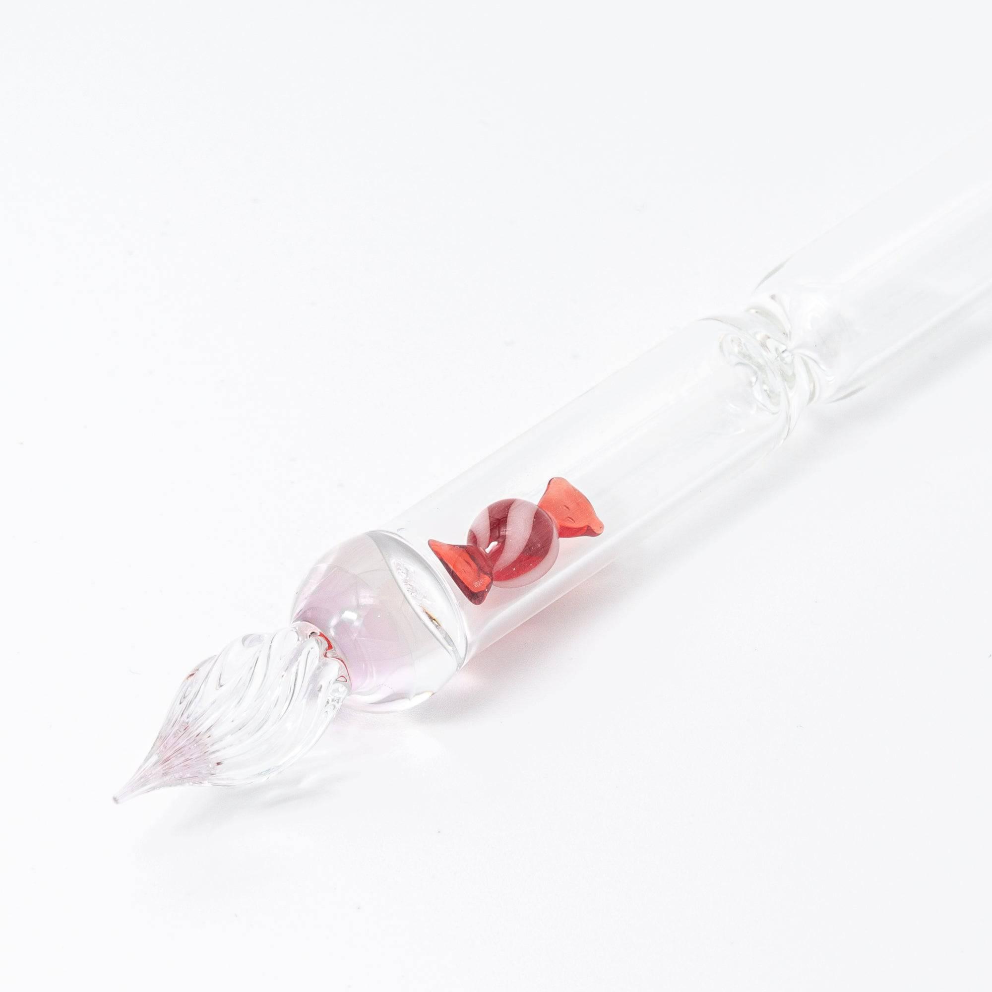 A red candy motif is captured inside this elegant glass pen, offering a whimsical yet sophisticated design for any stationery enthusiast.