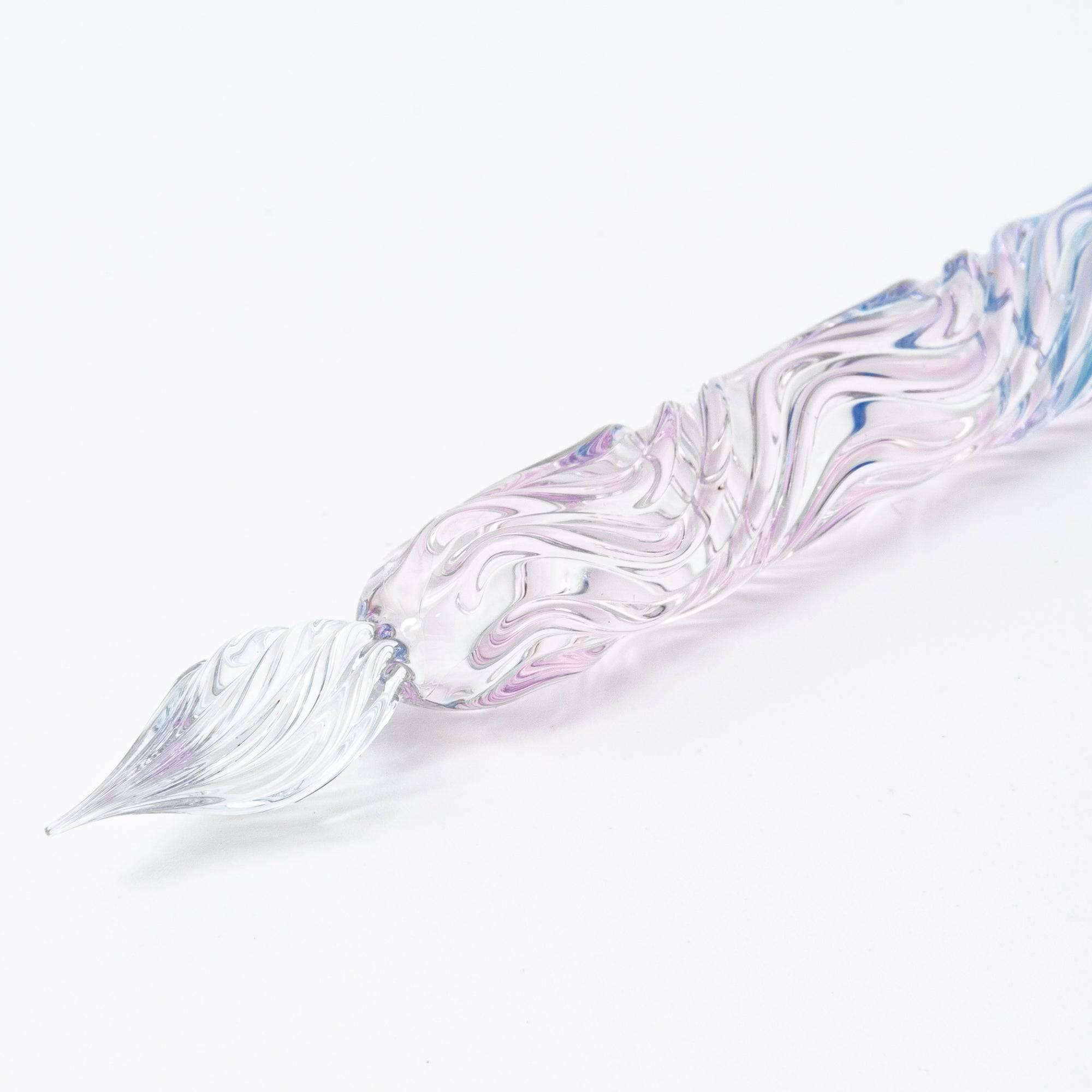 A clear glass pen with a blend of soft pink and blue hues, featuring a delicate sakura flower motif on the handle.