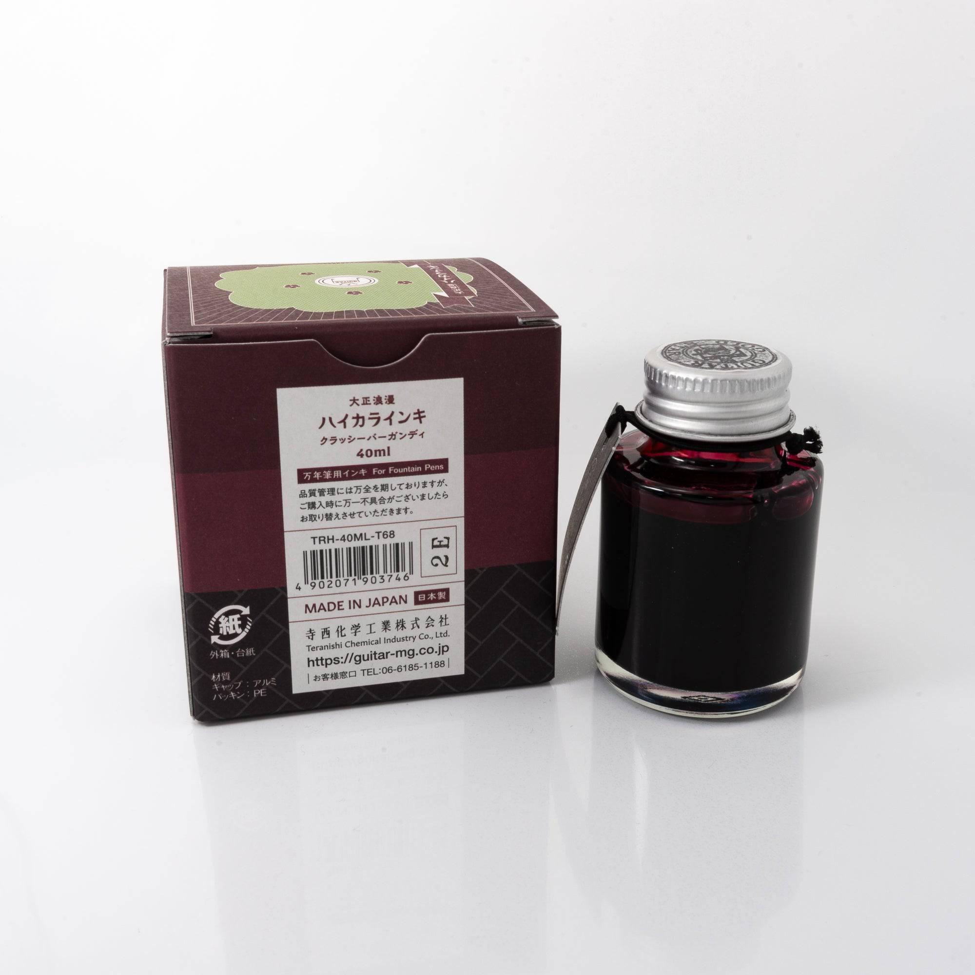 Top view of the Taisho Romance Classy Burgundy ink bottle, highlighting its deep burgundy ink, surrounded by natural wooden tones.  