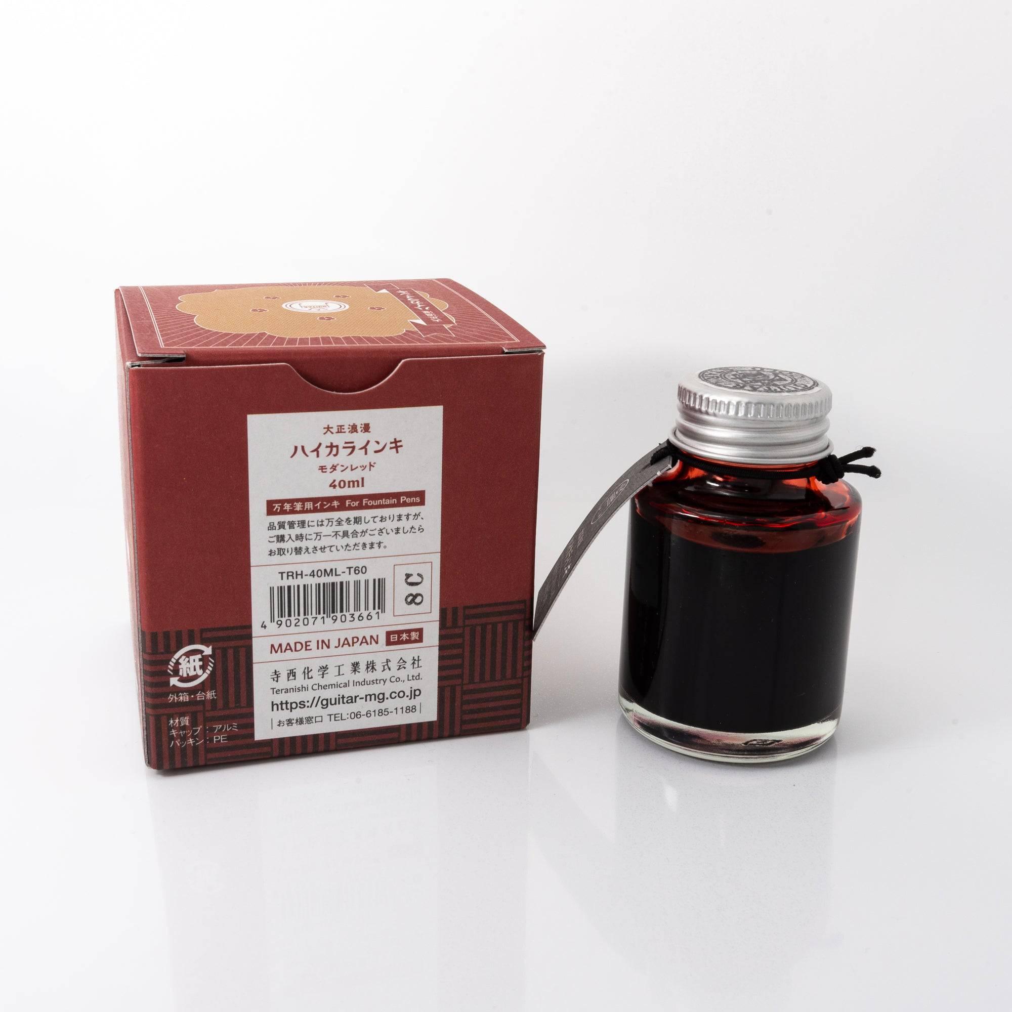 Top view of the Taisho Romance Modern Red ink bottle, highlighting its rich red ink, surrounded by warm wooden textures.  