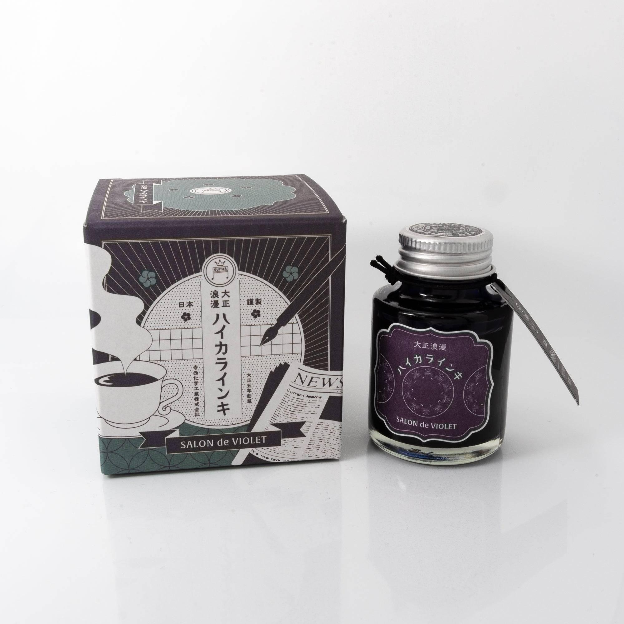 Taisho Romance Salon de Violet fountain pen ink bottle with a vibrant purple hue, placed on a wooden desk under natural light.  