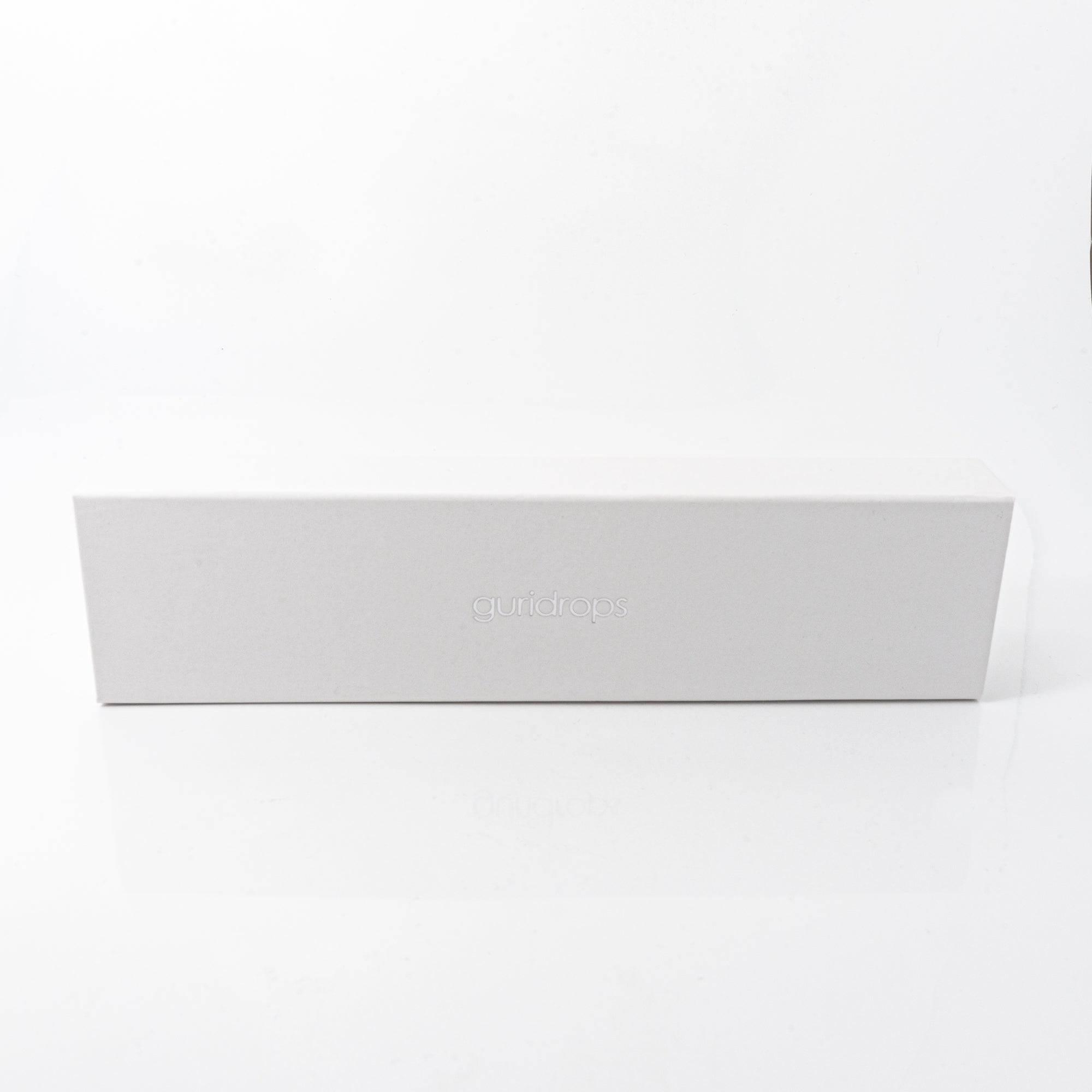 A simple, elegant white box with the "guridrops" logo embossed on it, used for packaging the glass pen.