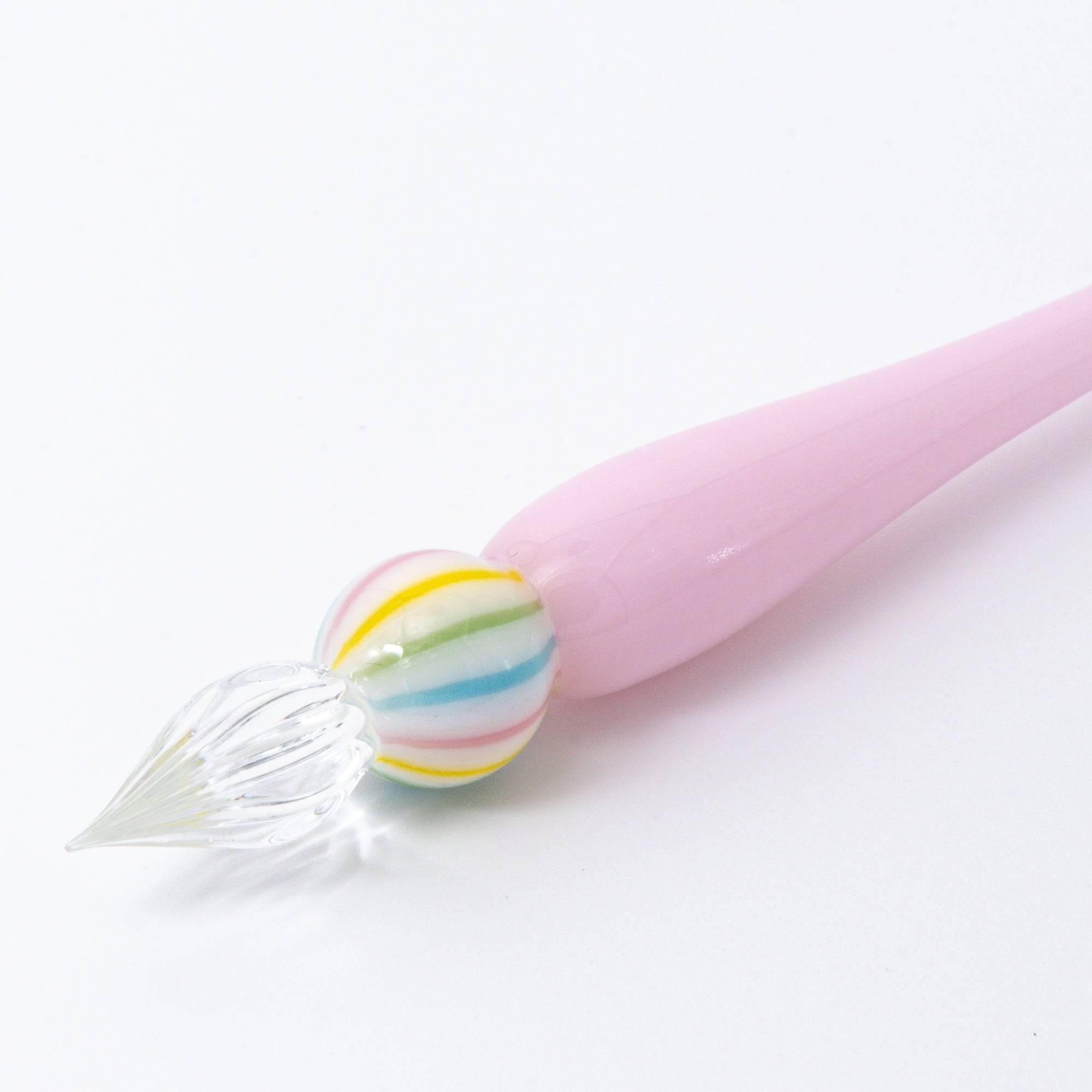 A pink glass pen inspired by traditional Japanese wagashi, featuring pastel-colored, marble-like glass beads at each end for a delicate and playful aesthetic.