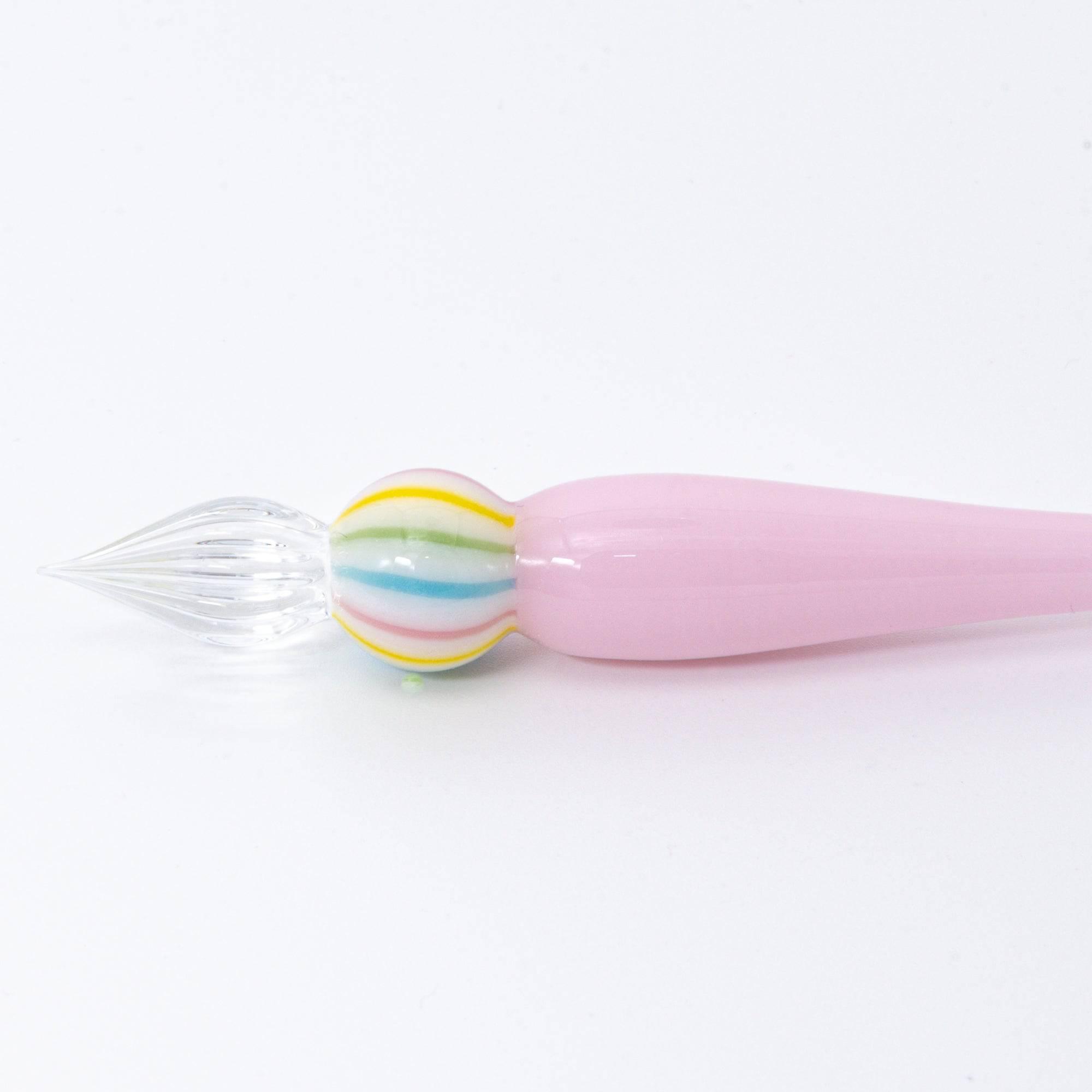 A pink glass pen inspired by traditional Japanese wagashi, featuring pastel-colored, marble-like glass beads at each end for a delicate and playful aesthetic.