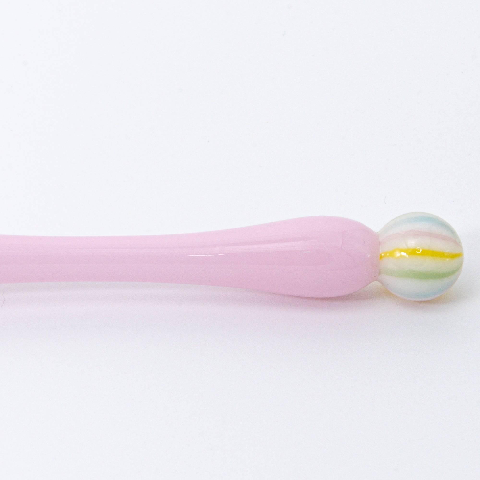 A pink glass pen inspired by traditional Japanese wagashi, featuring pastel-colored, marble-like glass beads at each end for a delicate and playful aesthetic.